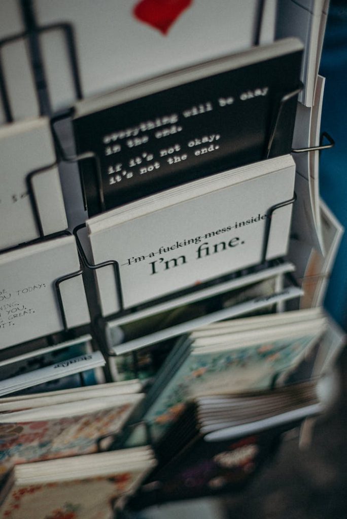 Close-up of diverse book covers in a bookstore rack showcasing various designs and quotes.